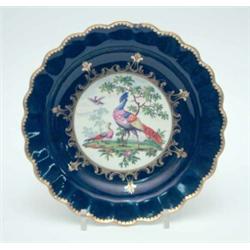 An 18th century Worcester saucer dish, painted with a single panel of exotic birds and landscape...