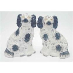 A pair of Victorian Staffordshire pottery comforter spaniels with black colouring and gilt chain...