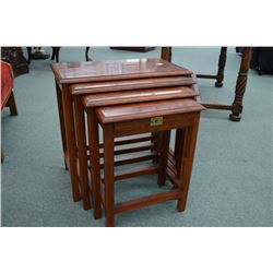 Four piece stacking nesting table each with metal inlaid tops and smallest one has a small drawer