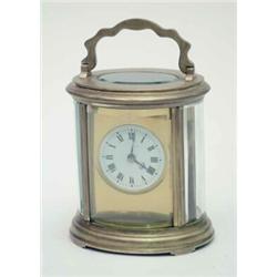 A late 19th century French oval brass carriage clock, with circular enamelled dial, movement stam...