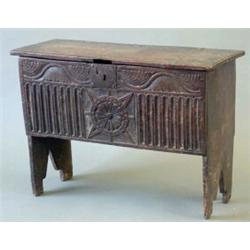 An early 17th century six plank oak coffer with carved front, 2ft.7ins....