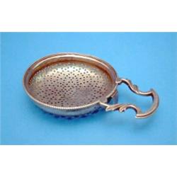 A George III silver lemon strainer, with scroll handle....