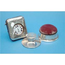 A silver mounted pin cushion casket, a travelling timepiece and an inkwell....