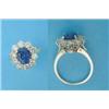 Image 1 : An 18ct gold cluster ring, claw-set with an oval sapphire in a border of 10 brilliant cut diamond...