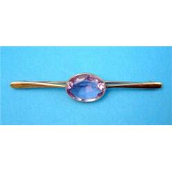 A gold bar brooch, collet set with an oval amethyst...