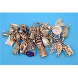 A 9ct gold curblink bracelet, with padlock clasp supporting 37 various charms...