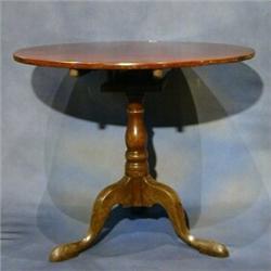 A Georgian mahogany circular snap top tea table with bird cage action, raised on gun barrel and t...