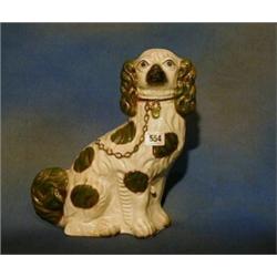 A Victorian figure of a seated Staffordshire Spaniel 13" high £50-75...