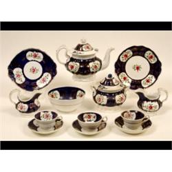 A Victorian Staffordshire Pottery Tea Service, painted floral vignettes on a dark blue ground (so...