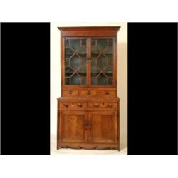 An Early 19th Century Oak Bookcase on Cupboard, the moulded cornice above a pair of bar glazed do...
