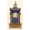 Image 1 : A Mantle Clock, the 10 cm diameter dial with Roman numerals, in a brass and champleve enamel case...