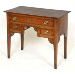 A George III Oak Lowboy, having a frieze drawer above a kneehole flanked by two drawers on taperi...