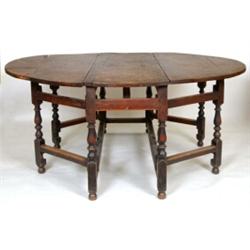 An 18th Century Joined Oak Double Gateleg Drop Leaf Table, the oval top on baluster turned legs (...