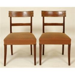A Set of Four Regency Mahogany Dining Chairs, the crest rails with greek style brass inlay, with...