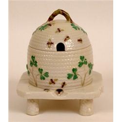 A Beleek Honey Pot and Cover, in the form of a wicker beehive, decorated shamrocks and bees  See...