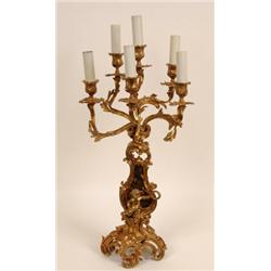 A Gilt Brass Six Light Candelabrum, of rococo design, the base applied a cherub, 59 cm  See illus...