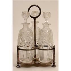 A Victorian Plated Three Division Bottle Stand, with three cut glass decanters and stoppers, 33 c...