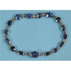 A Sixteen Stone Sapphire Bracelet, interspersed with sixteen diamonds, in an engraved silver colo...