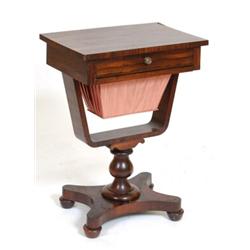 An Early Victorian Rosewood Work Table, having a frieze drawer above a pull out work bag, on balu...