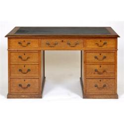 An Edwardian Oak Pedestal Desk, the leatherette inset top above an arrangement of nine drawers, 1...