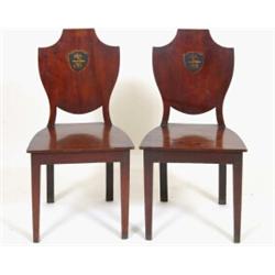 A Pair of George III Mahogany Hall Chairs, the shield shape backs painted crests, on square taper...
