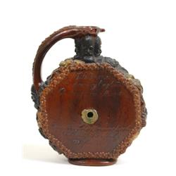 A 19th Century Earthenware Puzzle Jug, decorated in relief flowers, foliage and masks, the octago...