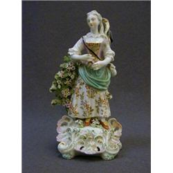 A CHELSEA-DERBY FIGURE, c.1765, lady with creel and fishing rod, rococo plinth, on glaze enamels ...