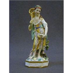 A DERBY FIGURE, c.1825, girl with keep net and fish in the folds of her drapery, on glaze enamels...