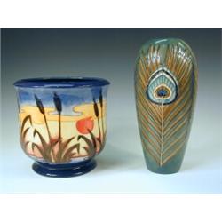 A William Moorcroft peacock feather pattern vase and a William Moorcroft bullrush and landscape p...