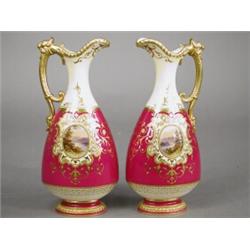 A pair of late 19th/early 20th century Coalport porcelain jugs, each with an oval cartouche frami...