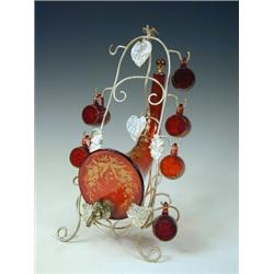 A 19th century cranberry glass liqueur set, having a cornucopia shaped barrel flanked by six cups...