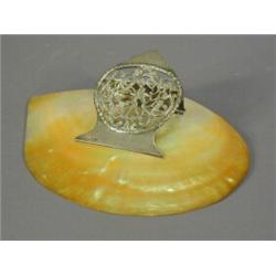 An Edwardian pierced silver desk paper clip, with a shell base, 22cm wide Est. 200/250...
