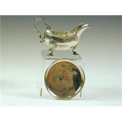 A George III silver sauceboat with three cast scalloped shaped feet, makers mark SM, London, 1761...