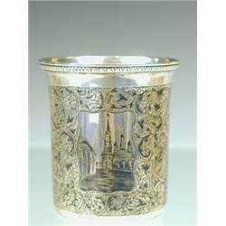A Russian silver and niello beaker decorated with two panels depicting churches and buildings on...