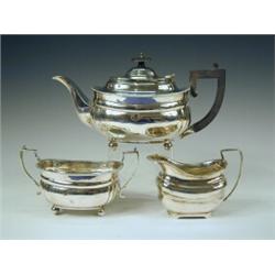 A silver three piece teaset comprising a teapot, matched milk jug and twin handled sugar bowl, wi...