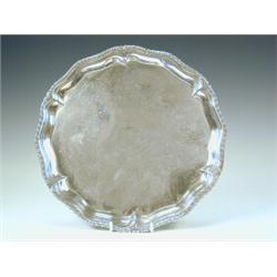 A George II silver salver with a shaped and gadrooned border, engraved decoration with a central...