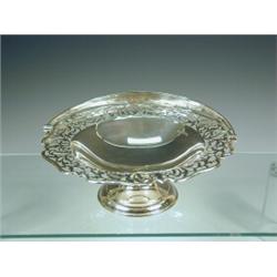 A silver basket of circular shape with a pierced border, swing handle and pedestal base, 1921, ap...