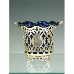 A Victorian silver sugar basket with a swing handle, pierced decoration and a blue glass liner, p...