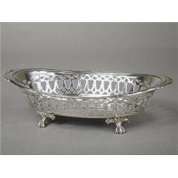 A late George V pierced silver oval dish on four claw and ball feet, Birmingham 1933, 21cm diamet...