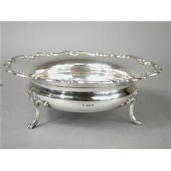 A late George V silver fruit bowl with an applied 'C' scroll rim, supported upon four paw feet, S...