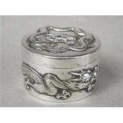 A late 19th century Chinese silver cylindrical powder box, embossed with dragons, with a silver g...