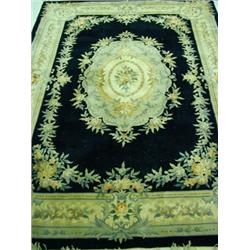A pair of large Chinese hand cut rugs with central floral medallions and floral borders on a blac...