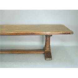 A long oak refectory table with a cleated plank top on turned end supports linked by a floor stre...