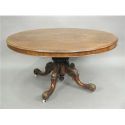 A Victorian mahogany oval dining table on a turned and carved stem and quadripartite legs, on cas...