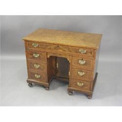 A part 18th century walnut kneehole desk, with eight drawers and a small recessed cupboard on tur...