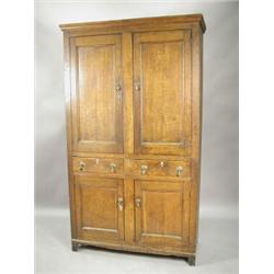 An early 19th century oak house keepers cupboard, with cupboard doors to the top and bottom with...
