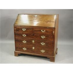 A George III mahogany bureau, the slope opening to reveal a pigeon holed interior, over two short...