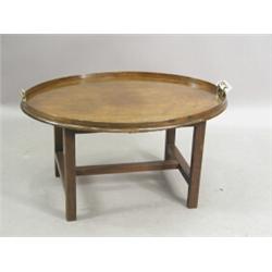 A George III oval mahogany butlers tray with two brass handles, on a modern low stand Est. 200/30...