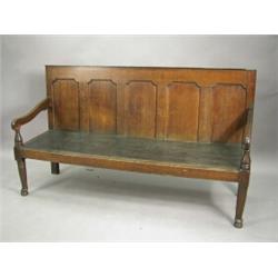 A George III oak settle with a five panel back, turned arm supports and cabriole front legs, 183c...