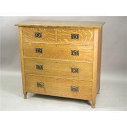 A Heal & Son Arts & Crafts oak chest of two short and three long drawers, with cast hoop handl...